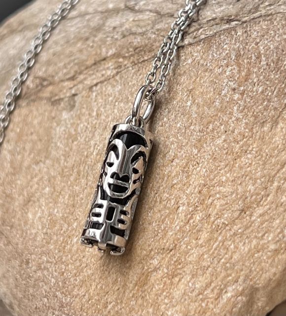 Un Tiki en argent, protecteur silencieux, au cœur duquel veille une agate noire profonde. Tiki traditionnel réalisé par un artisan en Polynésie française