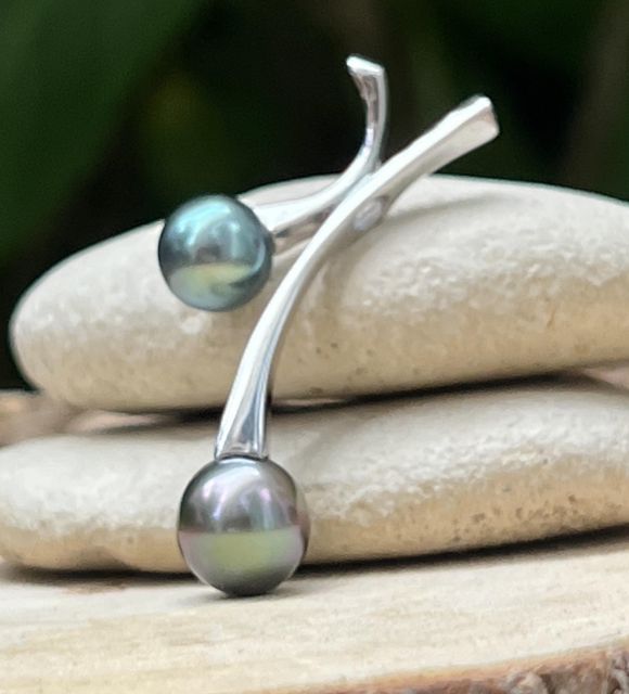 Pendentif en argent rhodié orné de deux perles de Tahiti AAA aux couleurs bleu lagon et bleu violine. Lustres excellents et élégance inspirée du Pacifique.