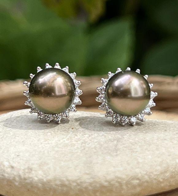 Deux perles nées du lagon, entourées d’un halo de lumière. Un reflet aubergine, un soupçon d’or rose, et la promesse d’un matin qui ne s’éteint pas.