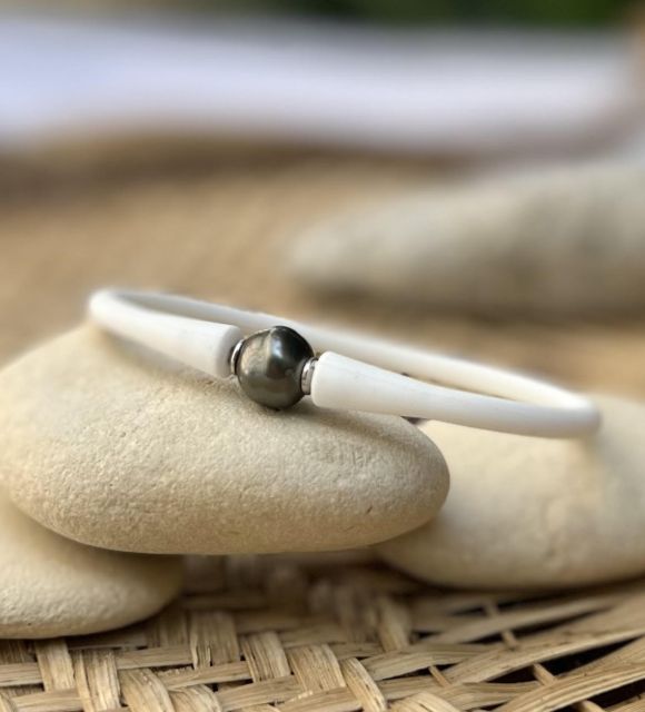 Affichez votre caractère et votre passion pour la Polynésie et son emblème, une véritable perle noire de Tahiti montée en bracelet silicone blanc mixte