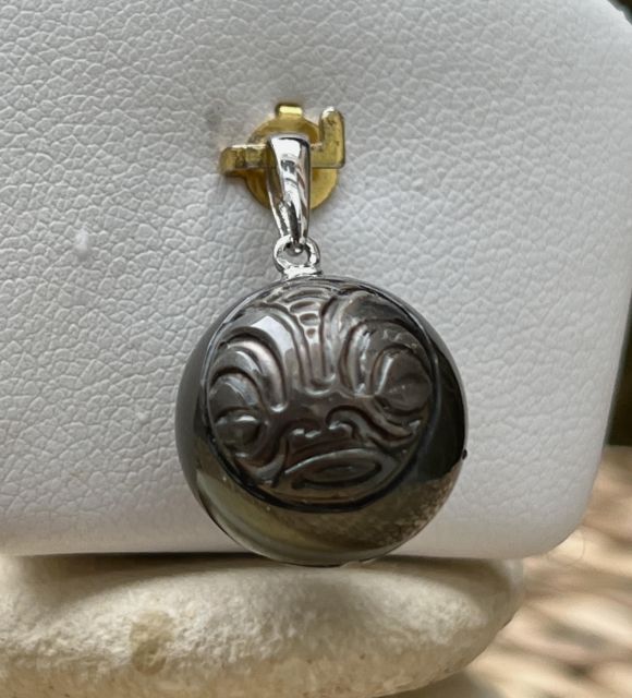 Anavai murmure la mémoire des eaux tranquilles et la force douce du lagon polynésien. Monté sur argent 925/00 rhodié, ce pendentif révèle une perle noire de Tahiti ronde de 15.10 mm.