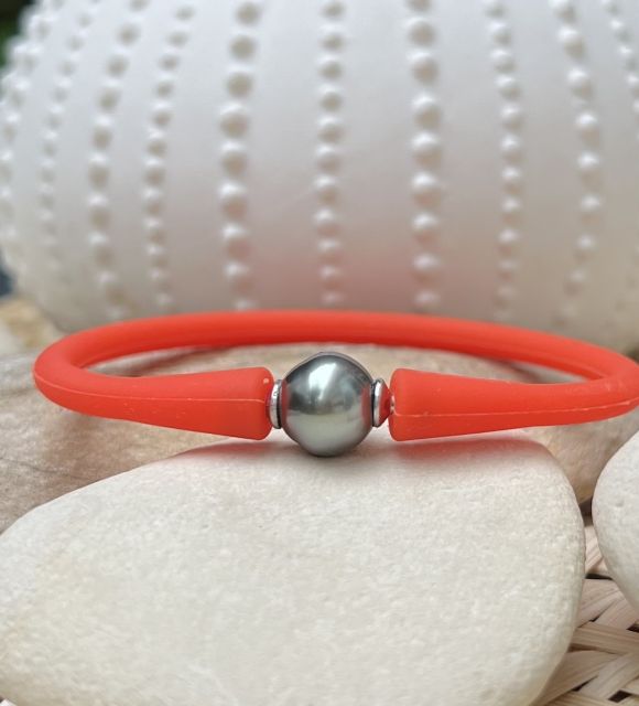 Découvrez notre bracelet en silicone orange ajustable orné d’une perle de Tahiti aux nuances intriguantes de gris et de bleu !